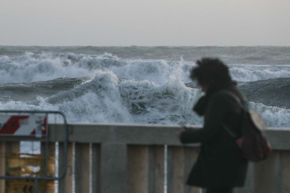 Ragazza che passeggia dinanzi al mare agitato