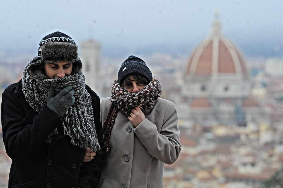 Due persone con cappotto, sciarpa e cappello