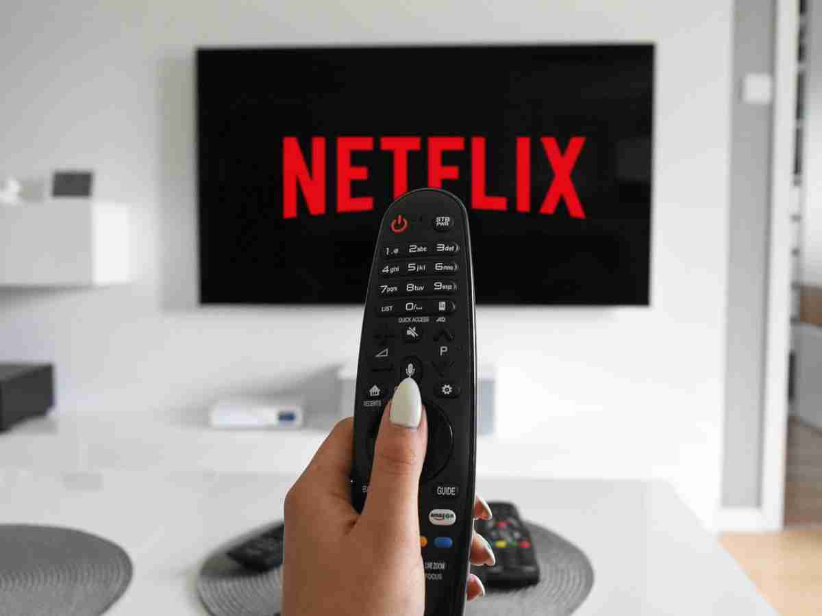 una persona mette Netflix con il telecomando