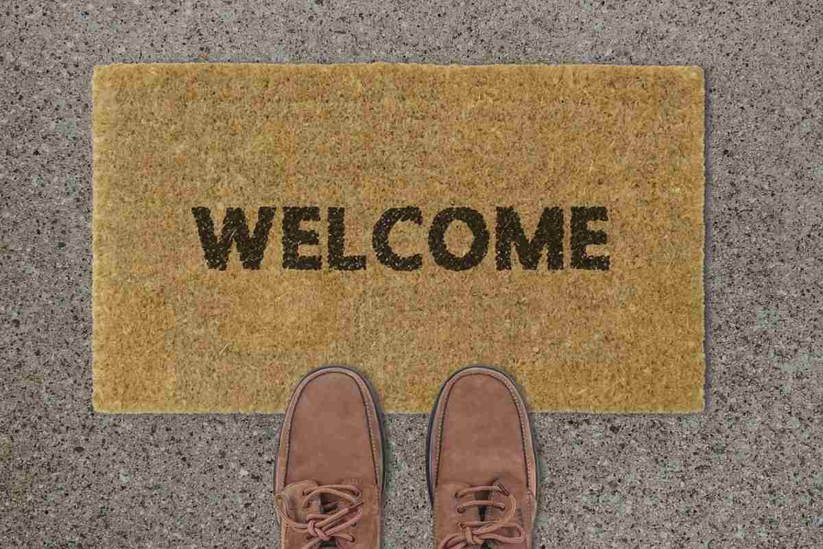 Zerbino davanti alla porta di casa con scritta 'Welcome'