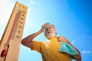 termometro con vicino uomo che soffre per il caldo