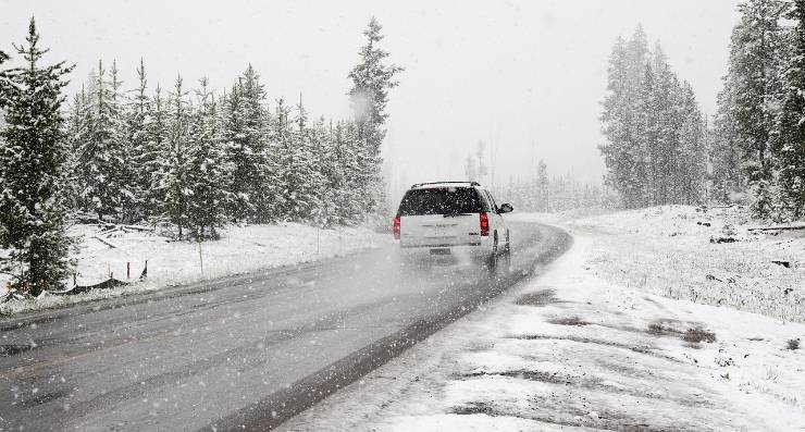 auto in transito su strada innevata