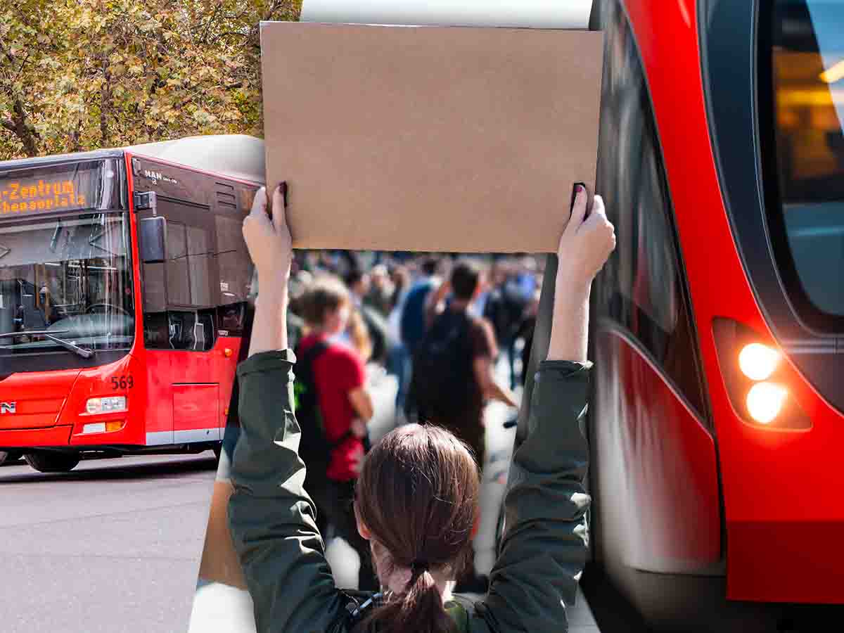 al centro una manifestante espone un cartello ai lati un autobus e un treno